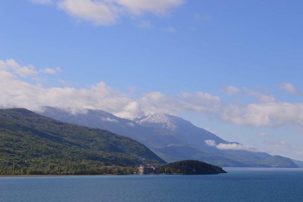 Serene landscape of Lake Ohrid with mountains under a clear blue sky in North Macedonia.